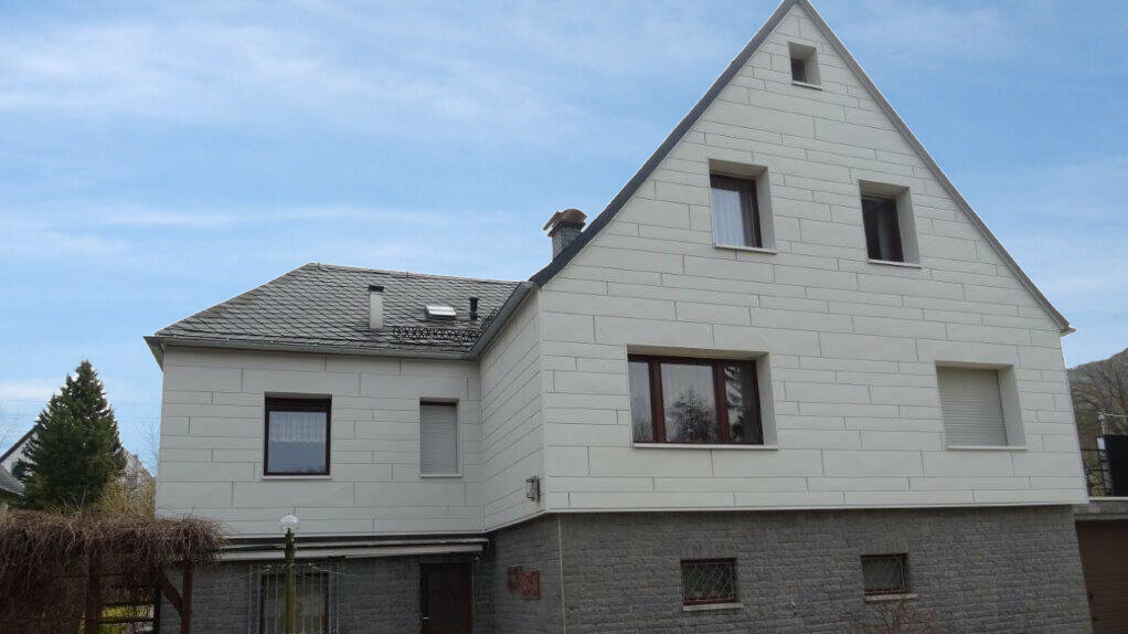 Fassadensanierung einer Putzfassade mit PREFA Sidings.X horizontal verlegt in Weiß mit grauem Klinker.