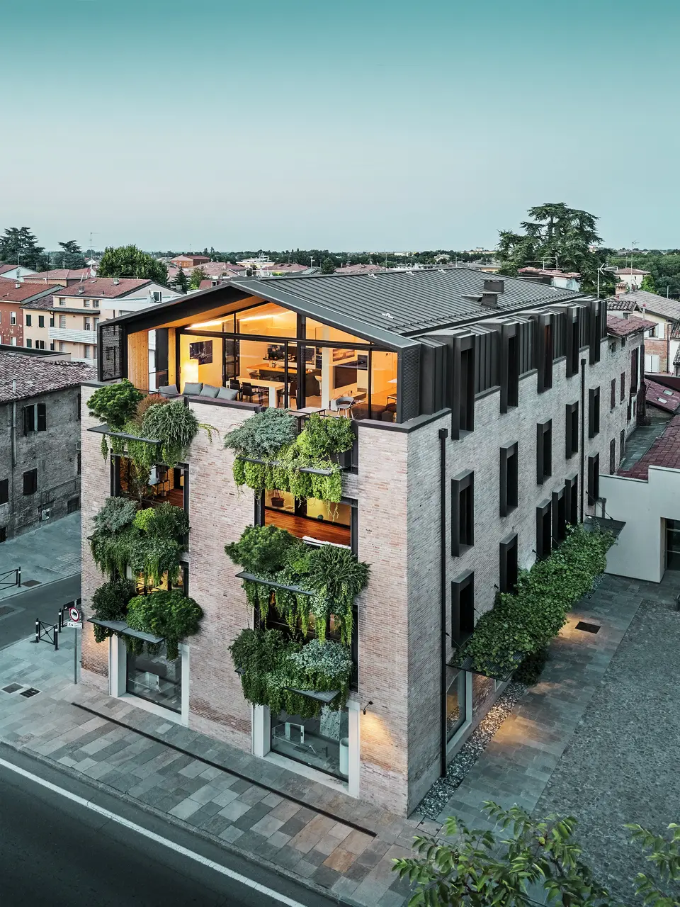 Nachhaltiges Wohnhaus in Italien mit PREFALZ-Aluminiumdach und grüner Ziegelfassade.