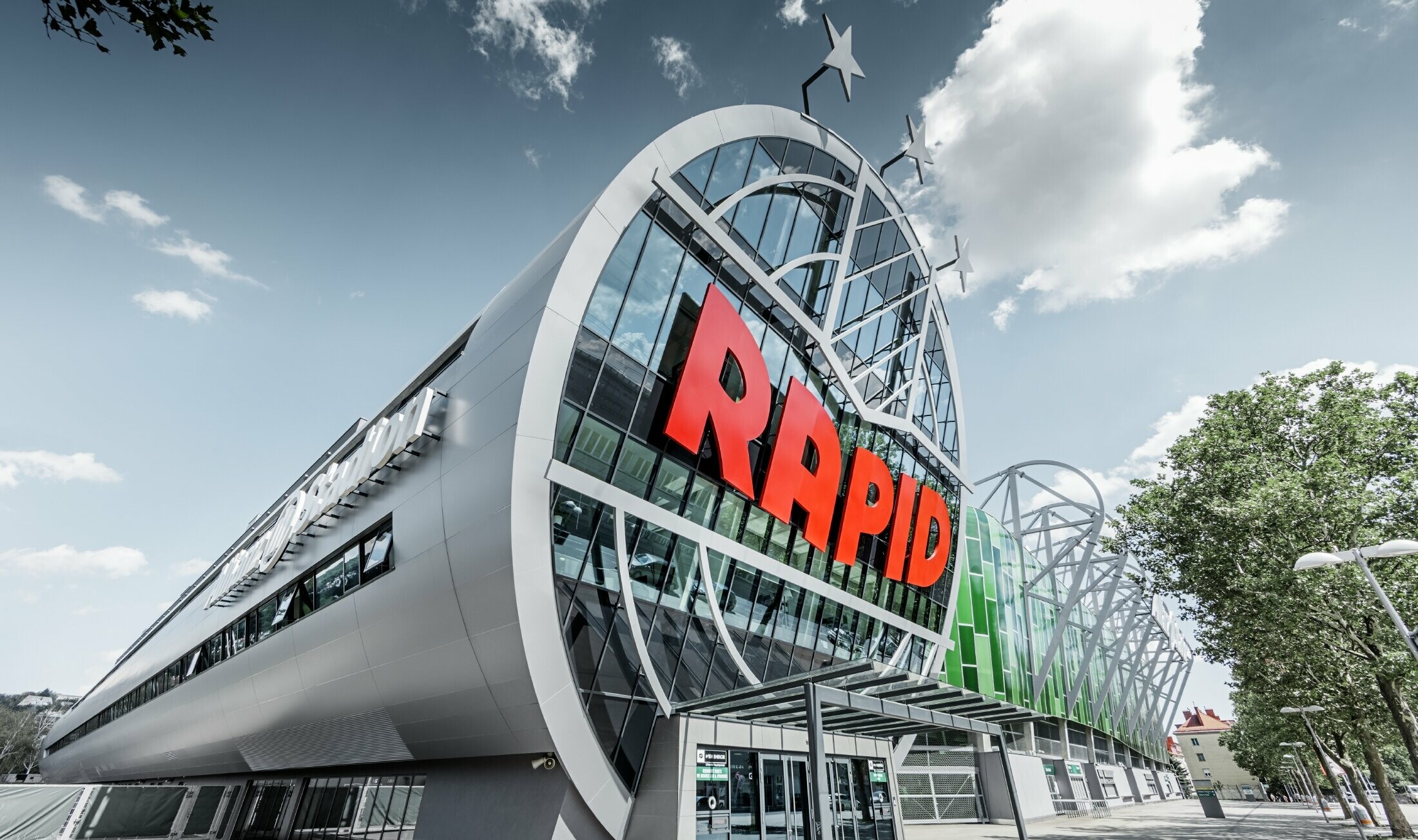 Ingången till Allianz Stadium med den stora SK Rapid Wien logotypen. ”Röret” med den stora glasfronten är täckt med panel i aluminiumkomposit från PREFA i silvermetallic.