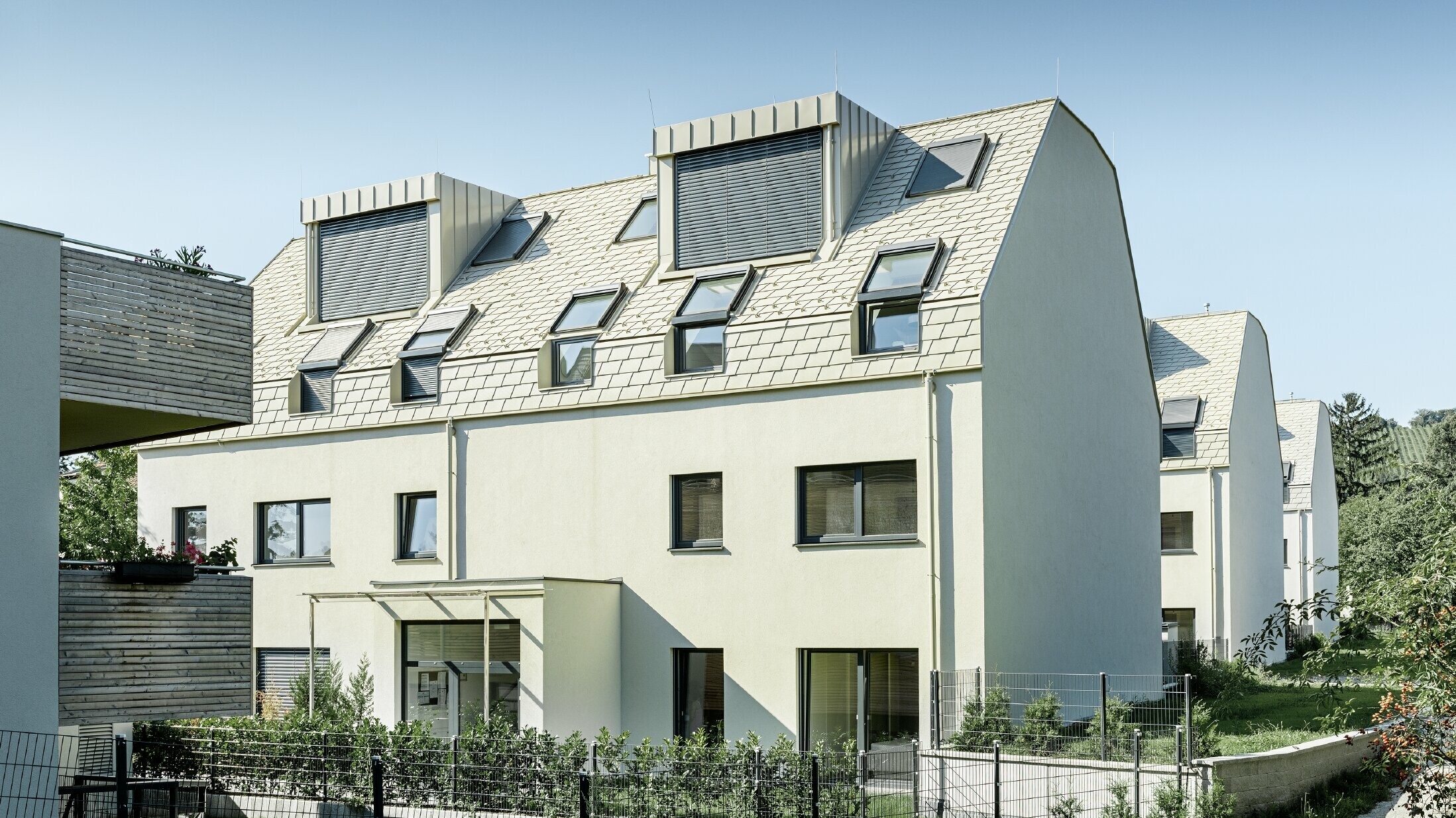 ny bostadsbyggnad med stort aluminiumtak och flera takfönster