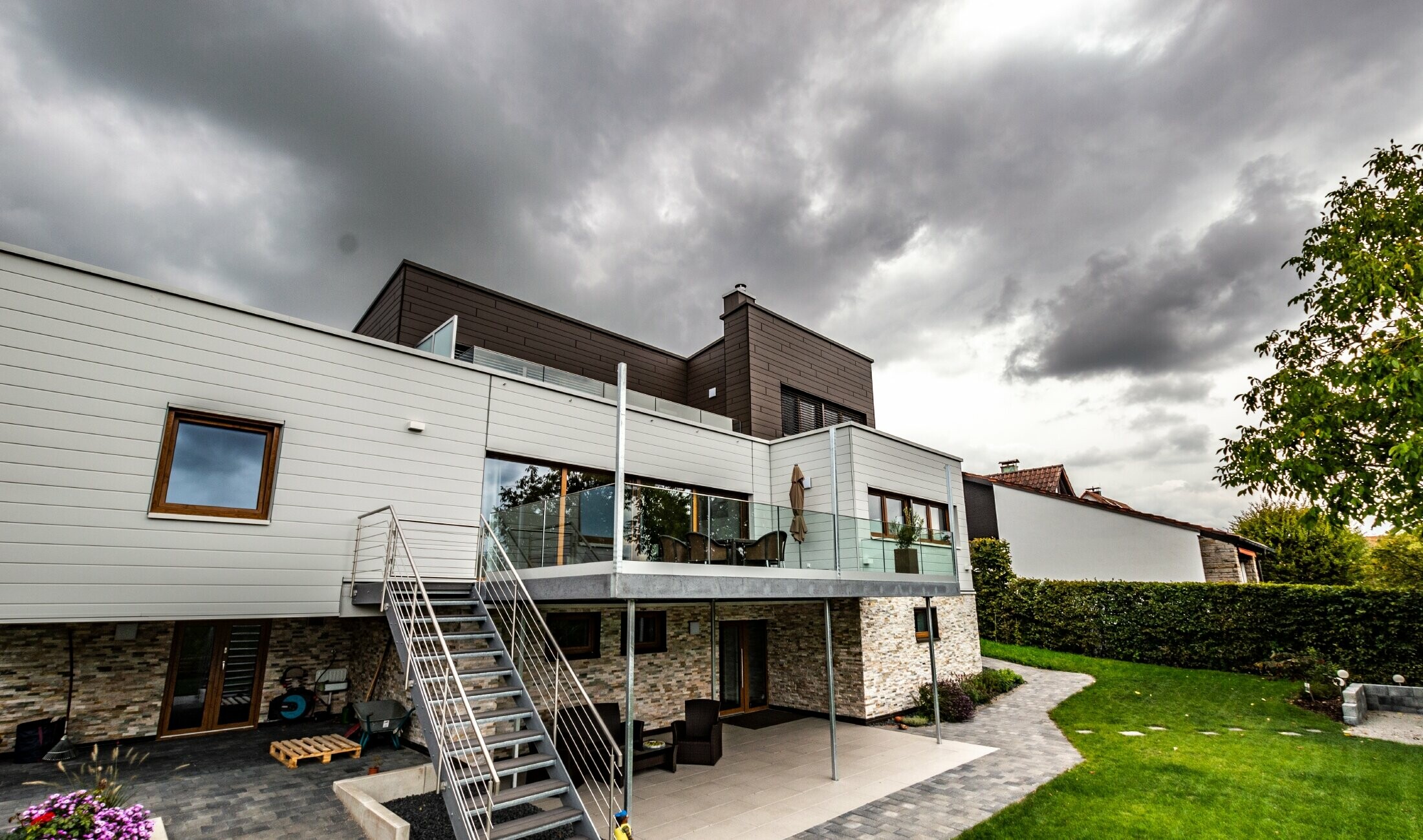 Bostadshus med platt tak och vit- och brun fasad med PREFA fasadpaneler som monterats vågrätt.