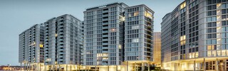 Vorderansicht der Belvedere Apartments am Abend. Die PREFA Profilwelle wurde mit Glas und Keramikelementen kombiniert