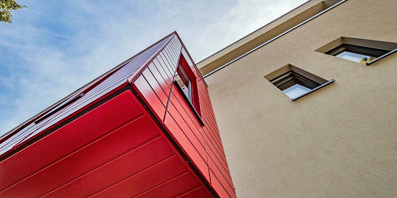 Burspråk med PREFA linjerad fasadpanel i rubinrött på en modern villa i Wernigerod, här är vyn på tillbyggnaden fotograferad underifrån.