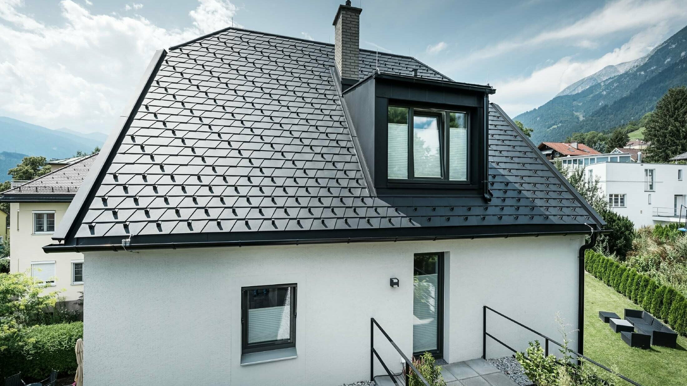 Liten villa med en takkupa. Taket täcktes med PREFA-takshingel i färgen P.10 svart. 