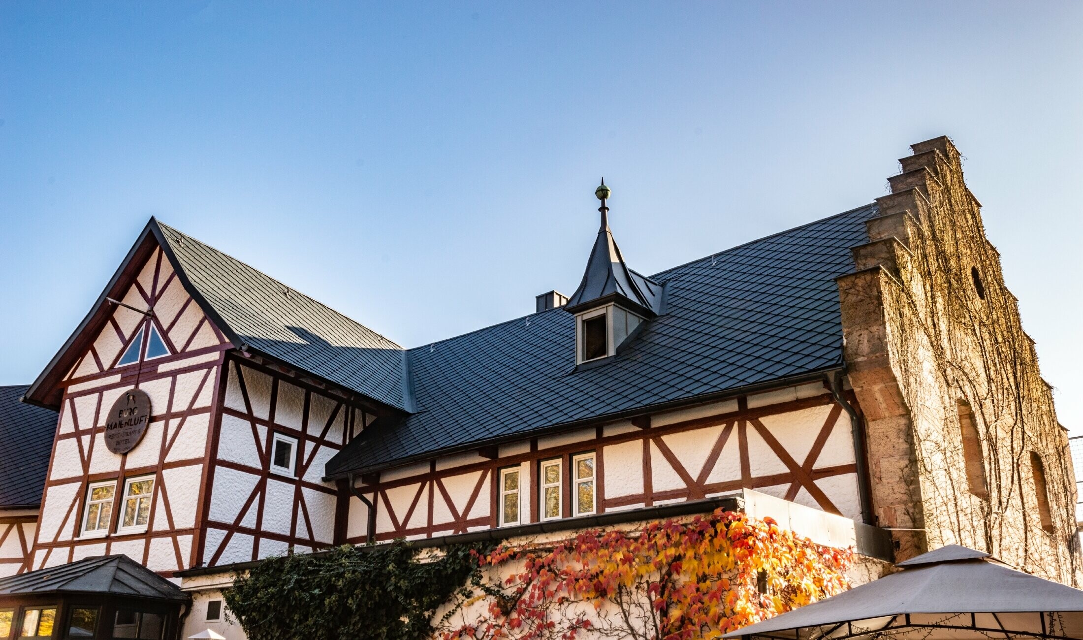 Hotel Burg Maienluft renoverades med PREFA väggromber 29 × 29 i antracitgrått, fasaden är en korsvirkesfasad.