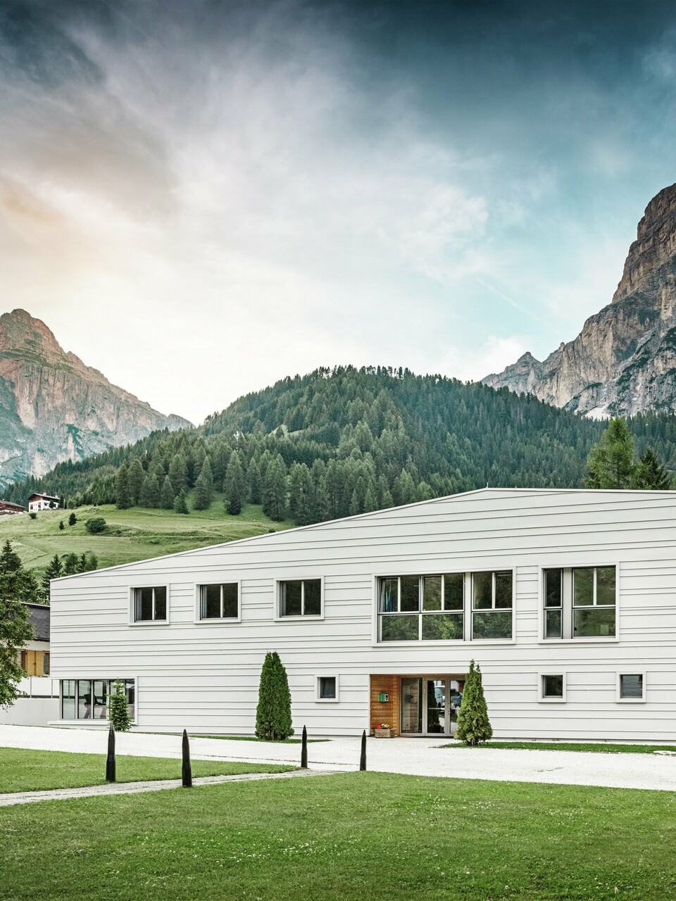 Moderne Militärarchitektur trifft auf alpine Landschaft: Die Kaserne „Tempesti“ liegt inmitten der Südtiroler Landschaft vor einer imposanten Bergkulisse. Die helle PREFALZ-Fassade in der Farbe P.10 Prefaweiß setzt klare Linien. Das helle Aluminium reflektiert das Sonnenlicht und verbessert das Raumklima.