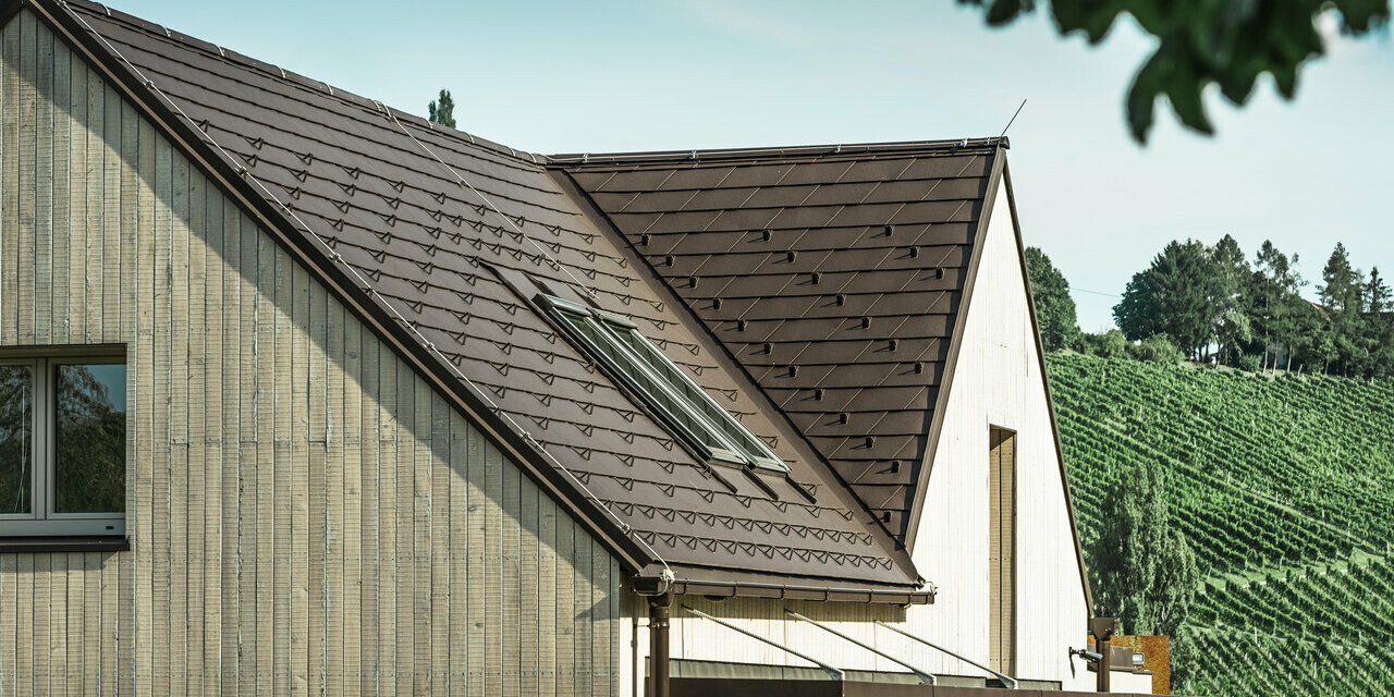 Enfamiljshuset med två sadeltak täcktes med PREFA takshingel i nötbrun. Takavvattningen sker via PREFA rektangulära rännor. Fasaden är täckt med väderbitet trä.