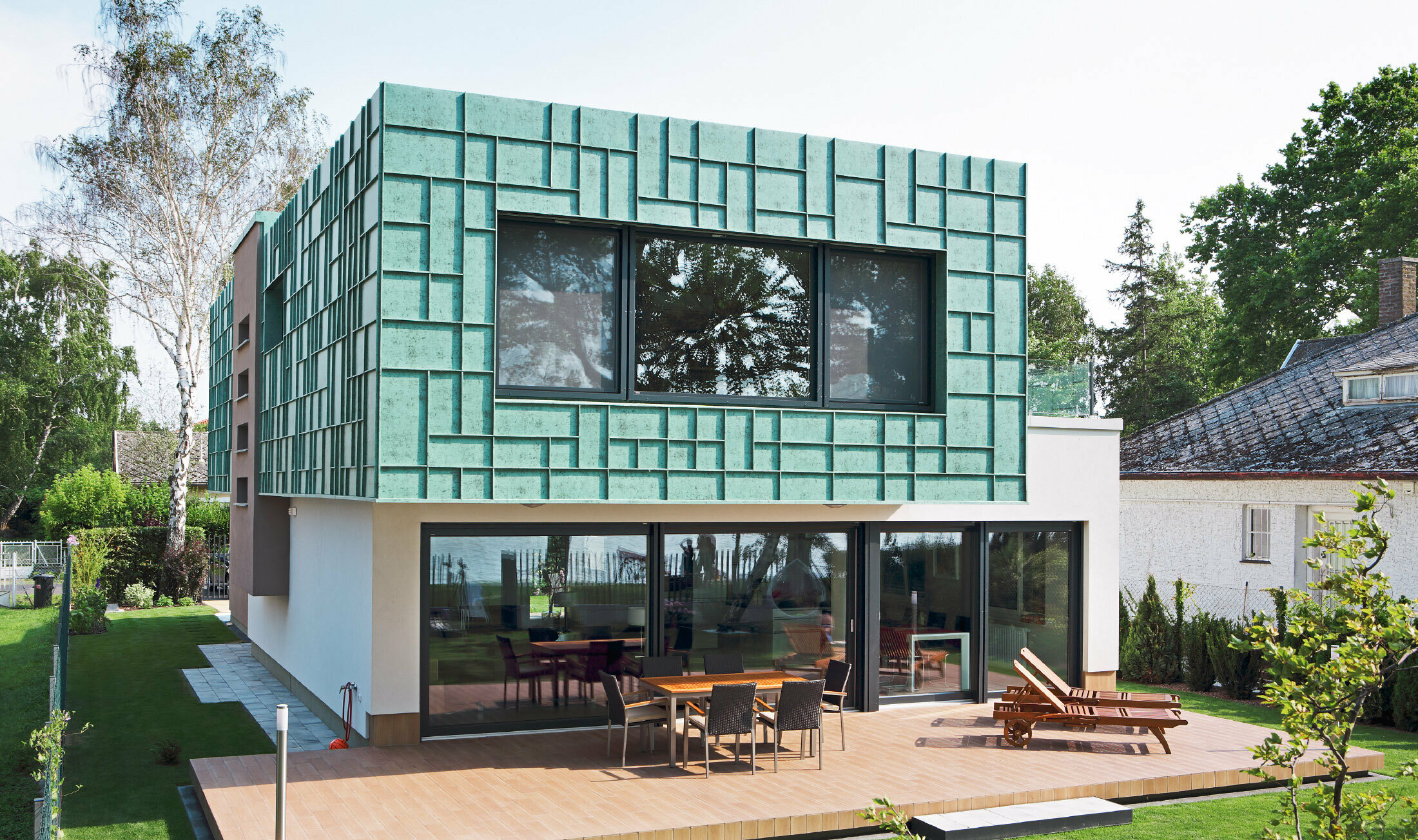 Ett modernt enfamiljshus med stormsäker fasad som klätts med PREFALZ i P.10 patinagrönt. 