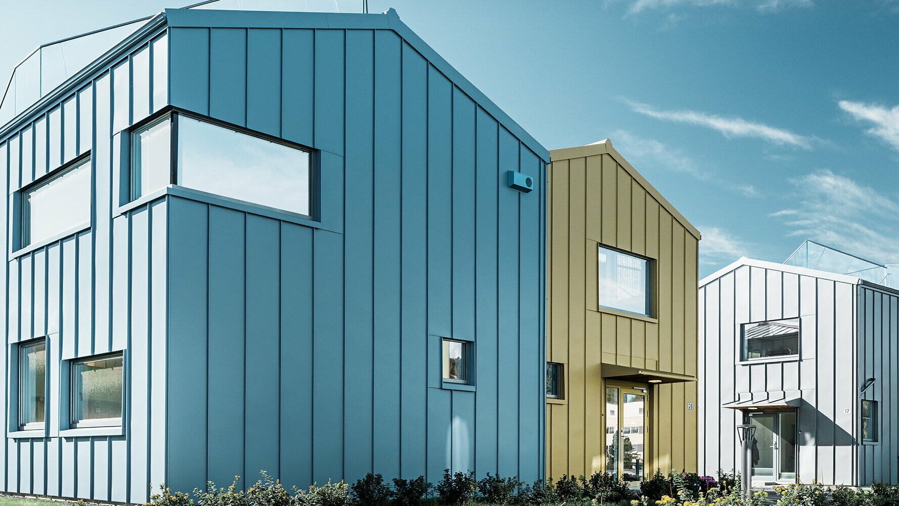 enfamiljshus i bostadsområde med färgglada tak och fasader av aluminium