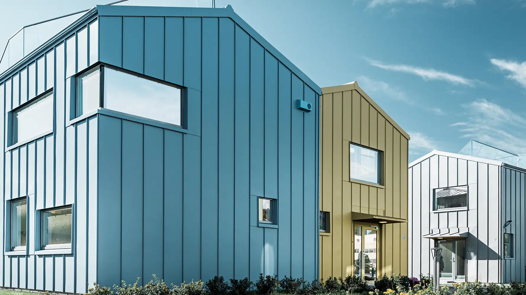 enfamiljshus i bostadsområde med färgglada tak och fasader av aluminium