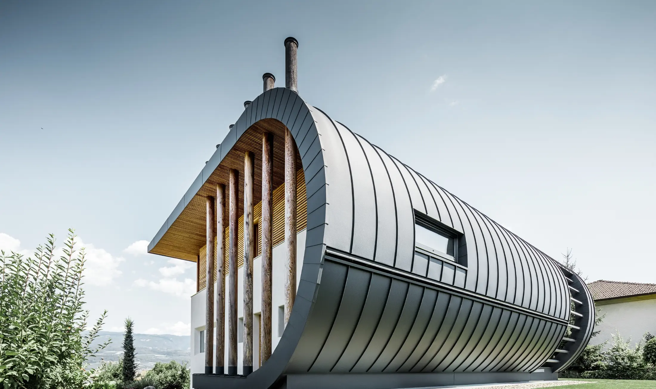 Böjd fasad på villan Casa Giovannini klädd med aluminium från PREFA - Prefalz i P.10 antracit.