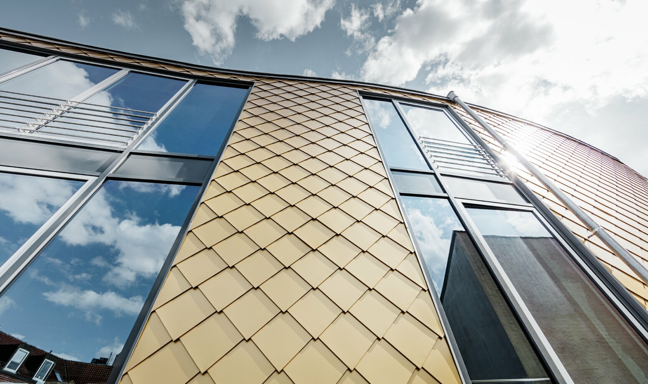 Gyllene aluminiumromber från PREFA i mayaguld, stora glaspartier på byggnadens fasad.