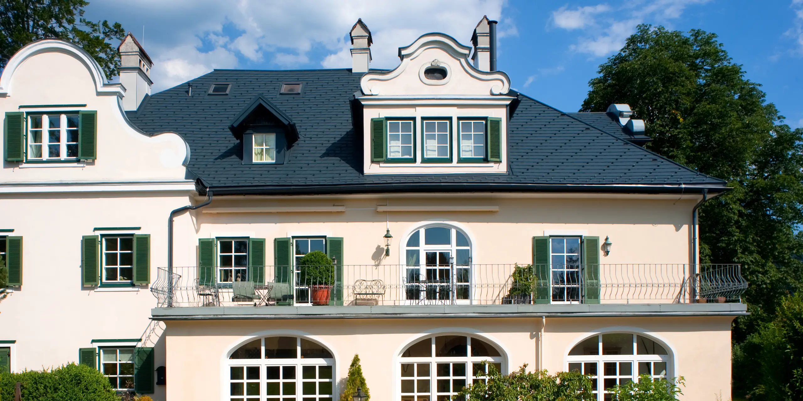 Nahaufnahme des Daches einer Villa in Bad Aussee, Österreich. Das Dach der Villa mit den prunkvollen Gauben wurde mit vielseitigen PREFA Dachschindeln in der Farbe P.10 Anthrazit eingedeckt.