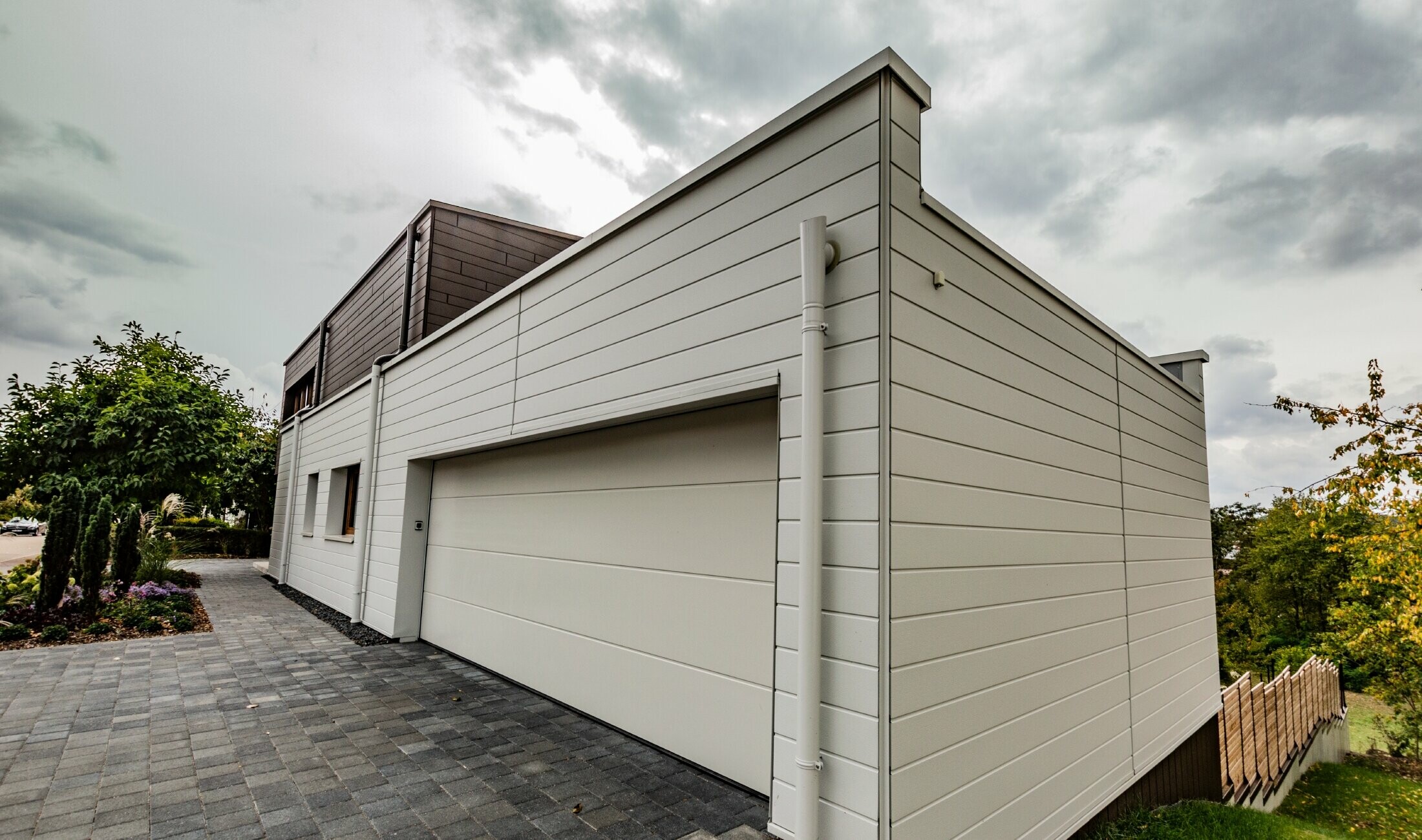 Garagebeklädnad med PREFA fasadpaneler vågrätt i vitt med vägganslutning för avvattning för fasad.