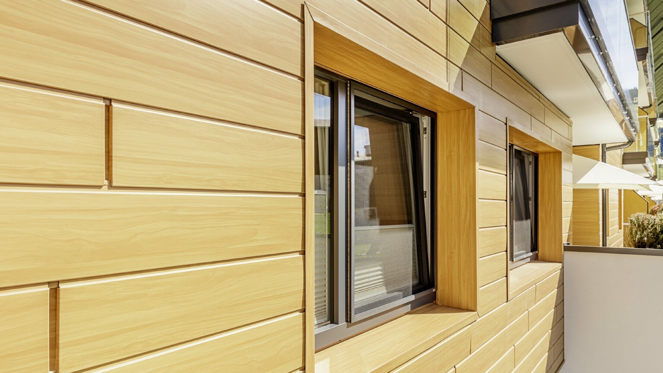 Detaljbild av en fönsterinfattning med fasadpaneler från PREFA i träimitation på Guthof Lutz i Schattwald.