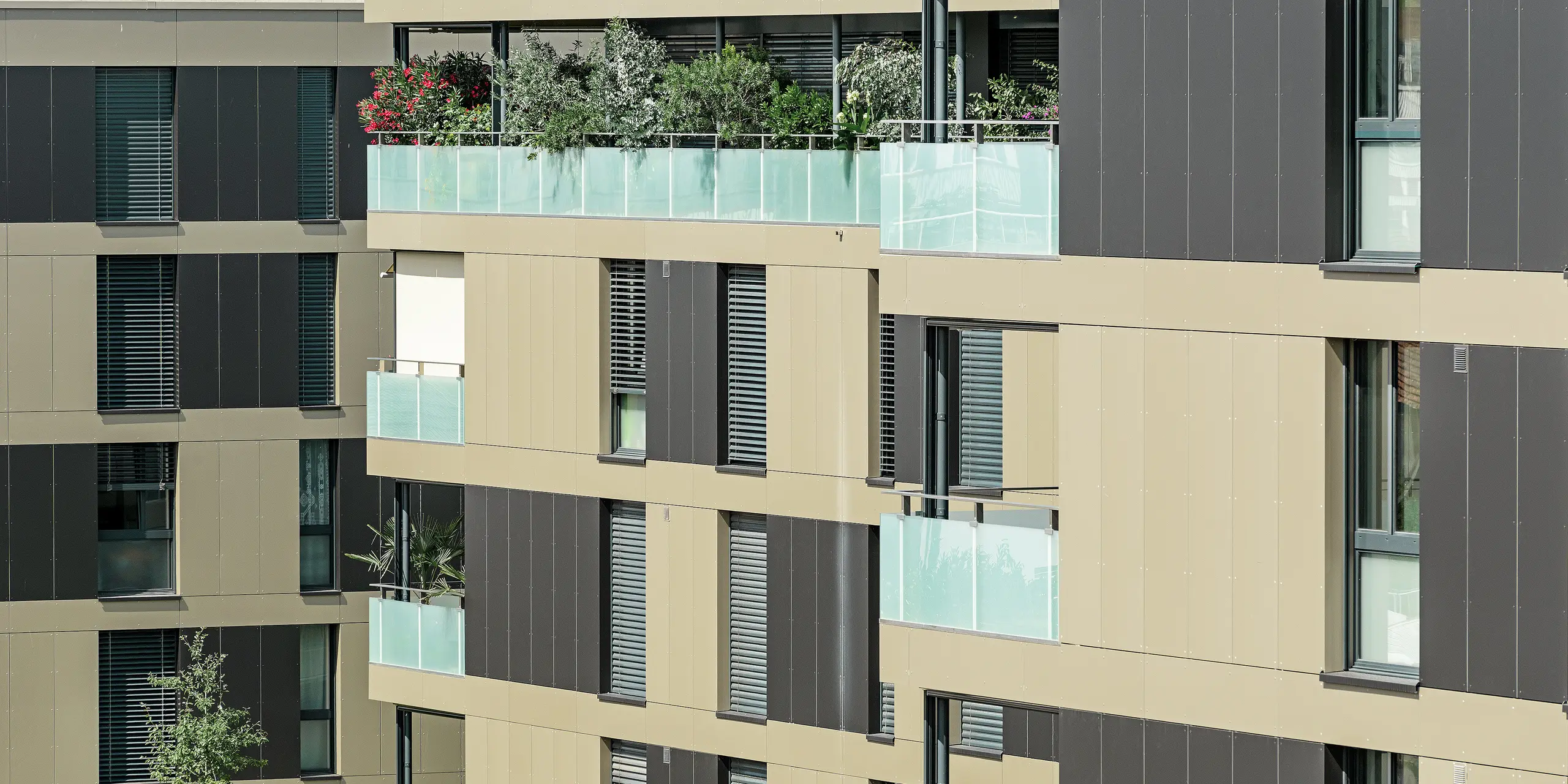 fyrkantig bostadsbyggnad med en aluminiumfasad i brons med svartgråa element