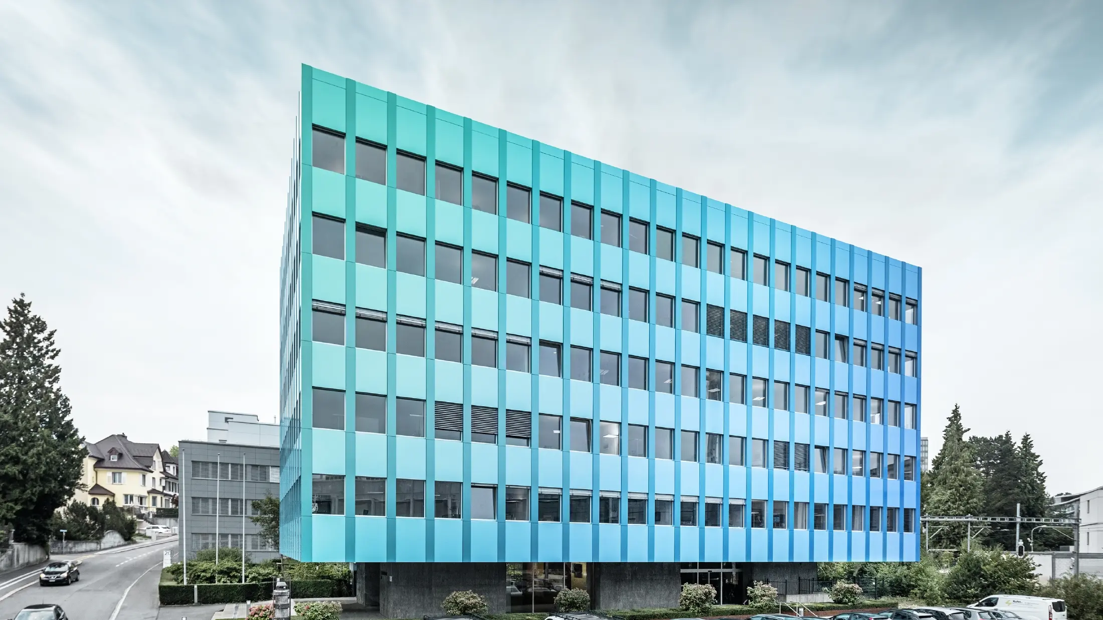 Sidovy av Wielandhuset i Aarau; fasaden är klädd med aluminiumkompositskivor PREFABOND från PREFA, som tack vare den speciella beläggningsprocessen skimrar i blågrönt.