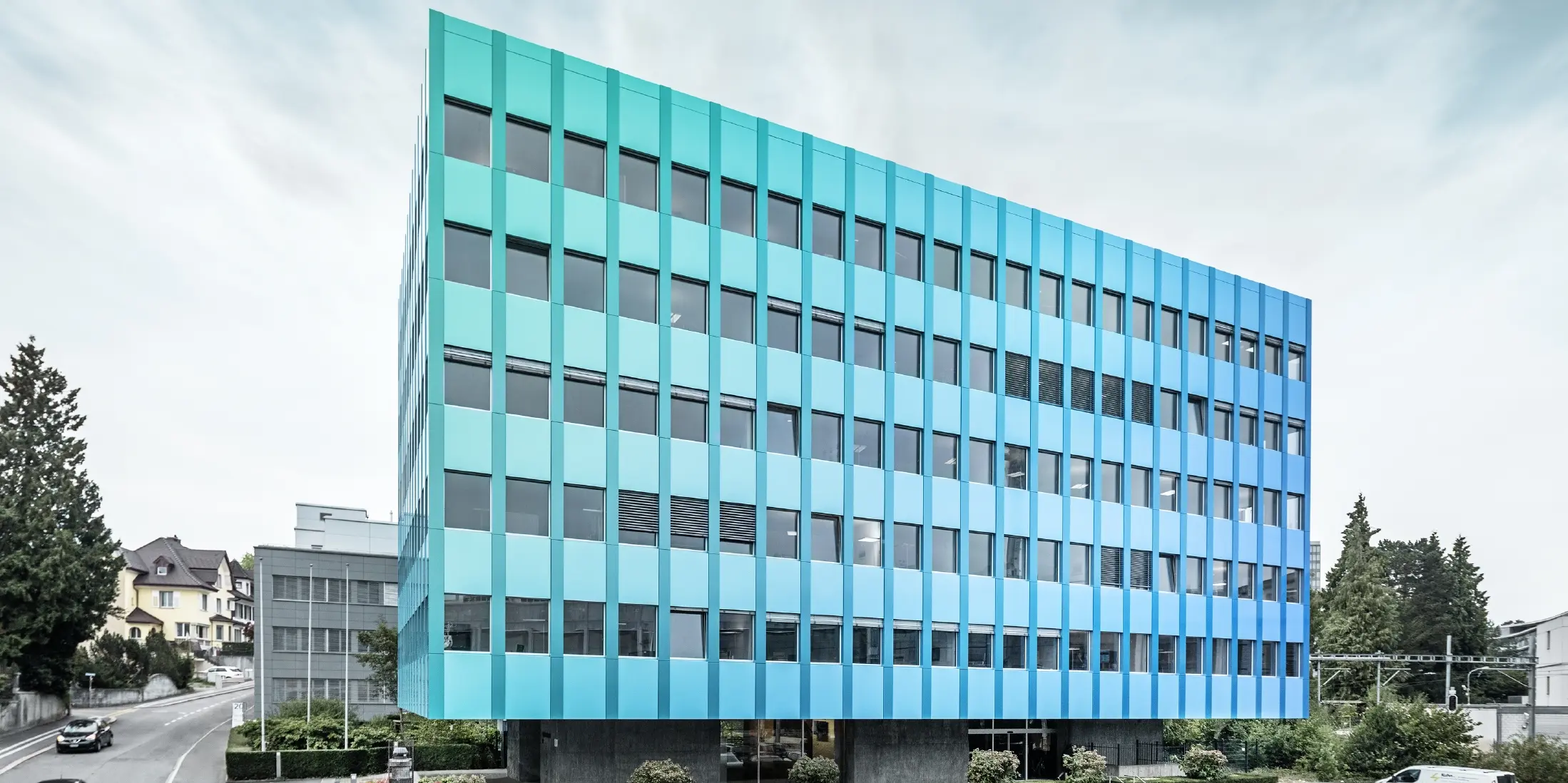 Sidovy av Wielandhuset i Aarau; fasaden är klädd med aluminiumkompositskivor PREFABOND från PREFA, som tack vare den speciella beläggningsprocessen skimrar i blågrönt.
