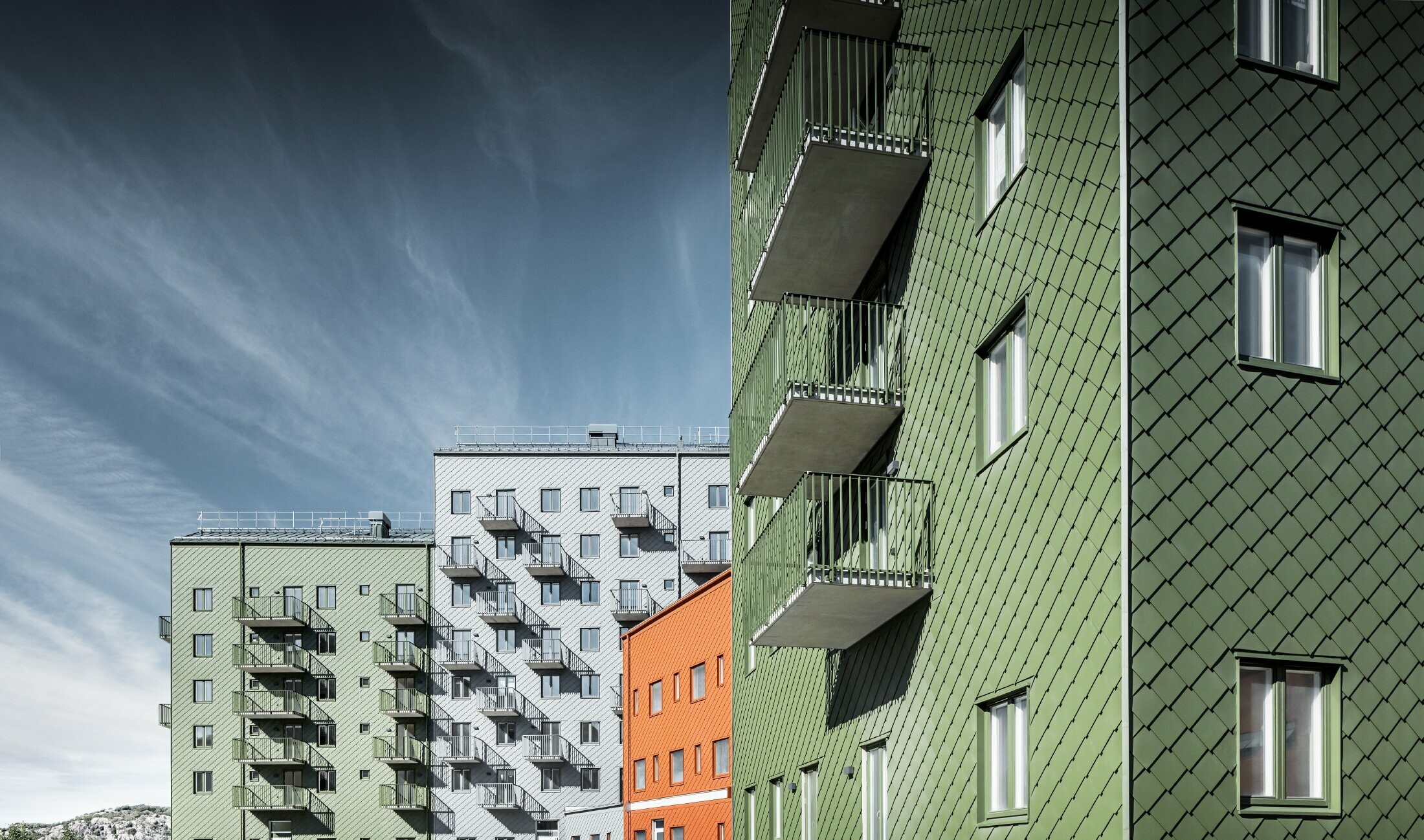 Flera bostadshus med PREFA väggromber 29 × 29 i färgerna tegelrött, olivgrönt och ljusgrått i Göteborg