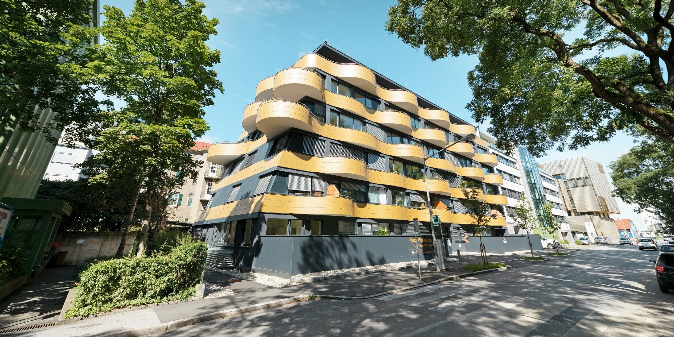 Bostadshuset "Goldene Welle" i Graz, Österrike med aluminiumkompositskiva i guld och rundade, vågiga balkonger 