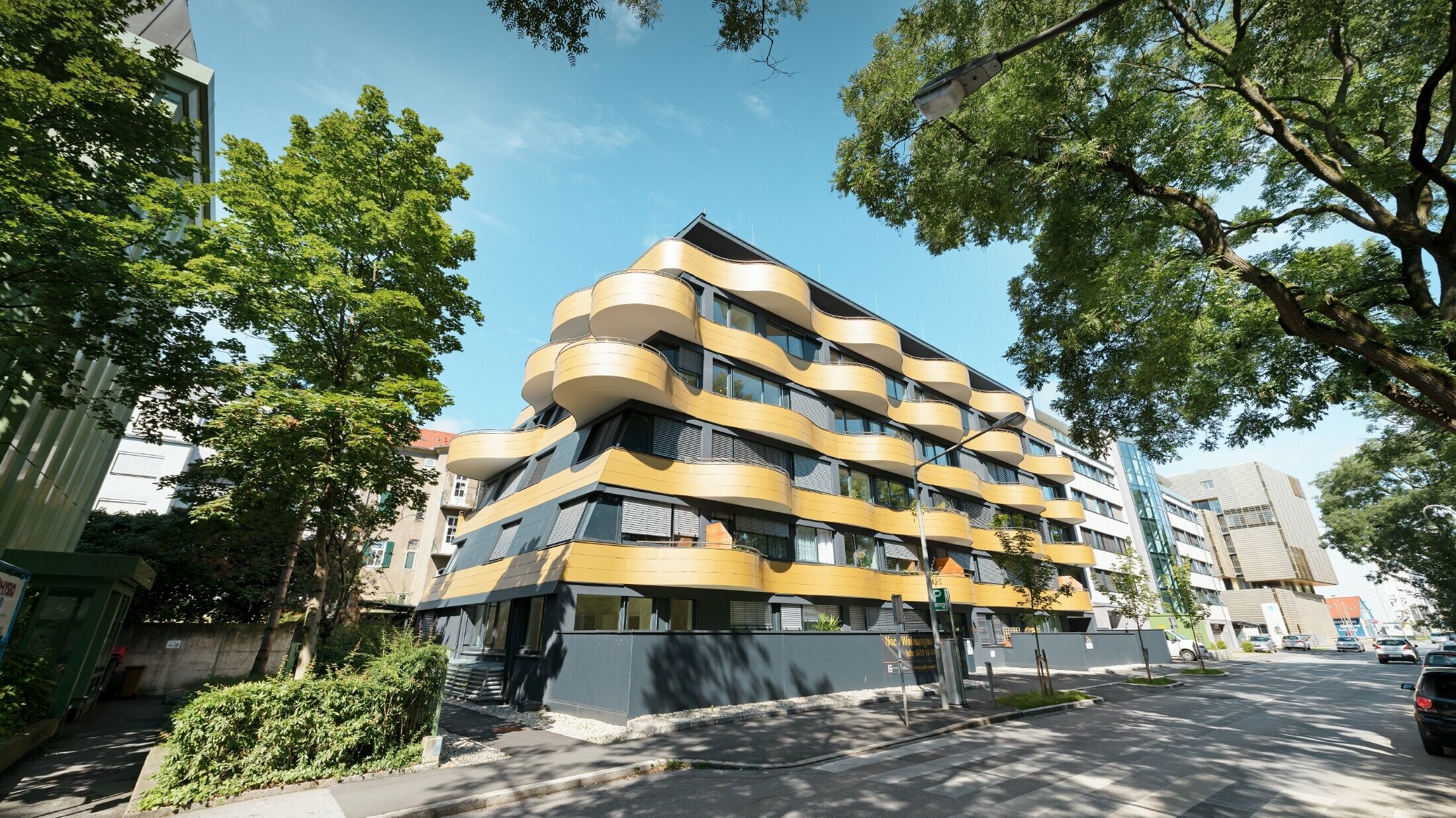 Bostadshuset "Goldene Welle" i Graz, Österrike med aluminiumkompositskiva i guld och rundade, vågiga balkonger 
